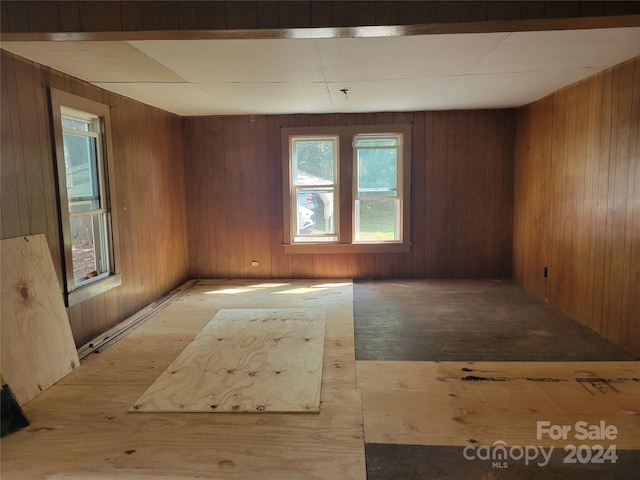 empty room with wood walls and hardwood / wood-style flooring