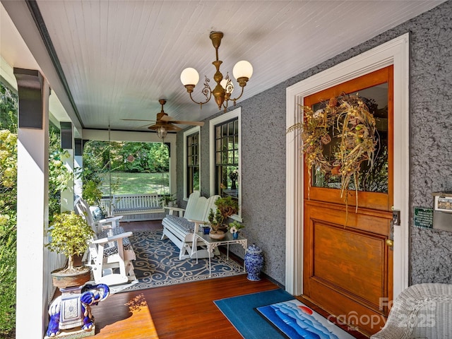 sunroom / solarium featuring ceiling fan with notable chandelier, wooden ceiling, and plenty of natural light