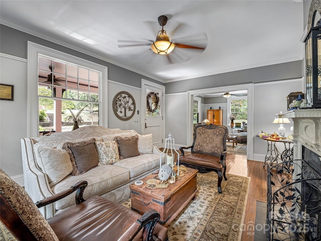 living room featuring crown molding, a high end fireplace, light hardwood / wood-style flooring, and a healthy amount of sunlight