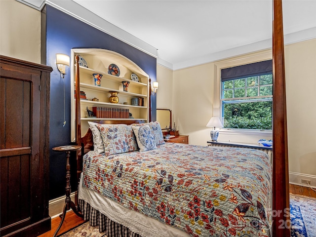 bedroom with ornamental molding and hardwood / wood-style flooring