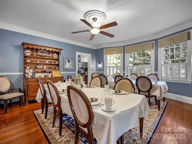 dining room with dark hardwood / wood-style flooring, ornamental molding, and ceiling fan