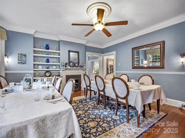 dining space with ceiling fan, ornamental molding, dark hardwood / wood-style floors, and built in shelves