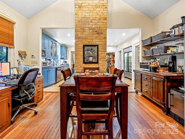 dining room featuring light wood-type flooring and vaulted ceiling