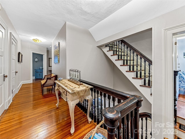 interior space with a textured ceiling and hardwood / wood-style flooring