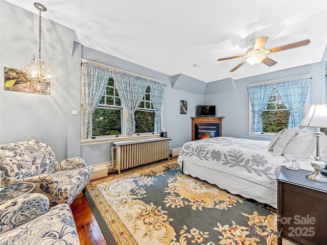 bedroom featuring ceiling fan, dark wood-type flooring, and radiator