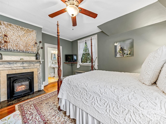 bedroom featuring ensuite bathroom, hardwood / wood-style floors, ceiling fan, ornamental molding, and radiator