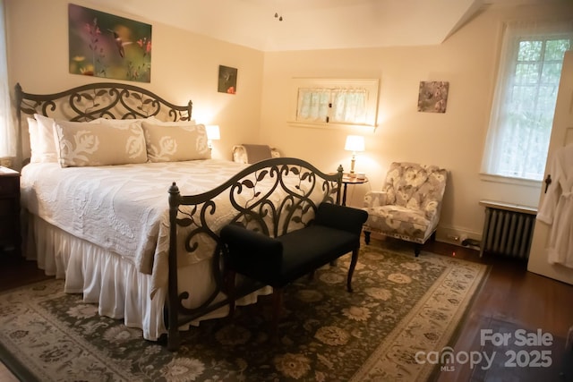 bedroom with dark wood-type flooring and radiator