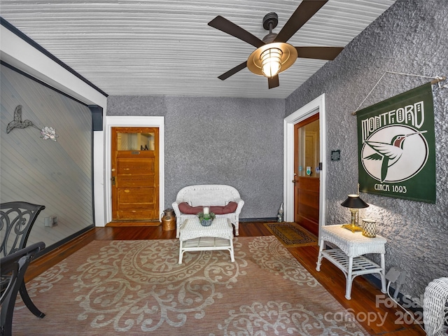 sitting room featuring ceiling fan and dark wood-type flooring