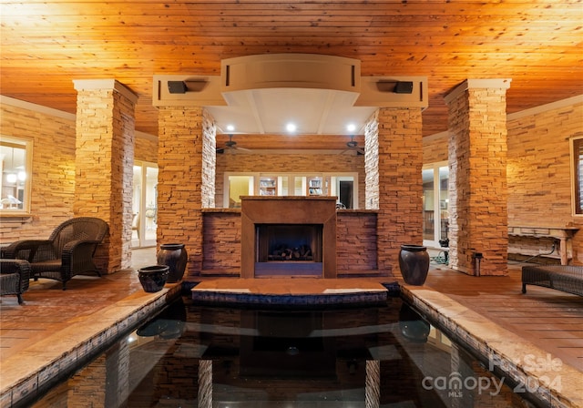 game room featuring a healthy amount of sunlight, wooden ceiling, and a fireplace