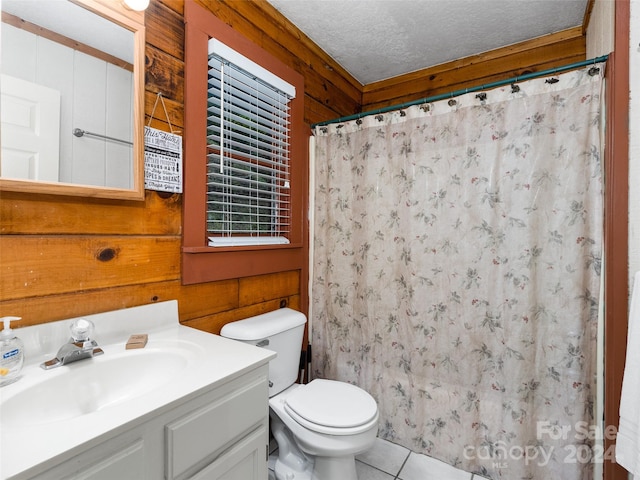 bathroom featuring wood walls, vanity, toilet, and a textured ceiling