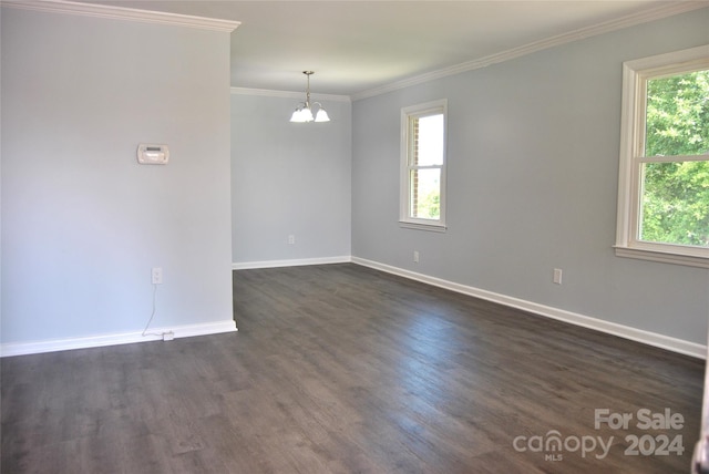 unfurnished room with ornamental molding, dark hardwood / wood-style floors, and an inviting chandelier