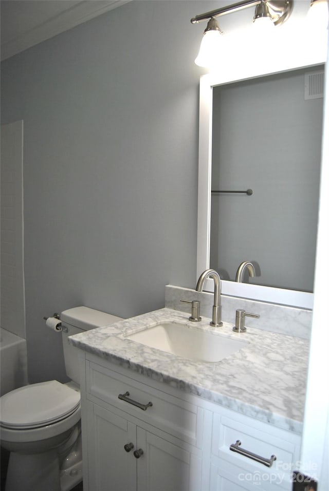 bathroom with crown molding, vanity, and toilet