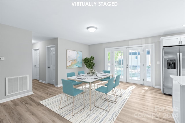 dining room featuring visible vents, light wood finished floors, baseboards, and french doors
