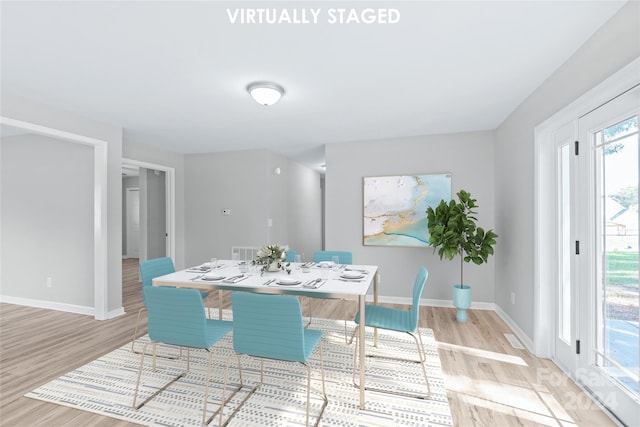 dining area featuring light wood finished floors, baseboards, and visible vents