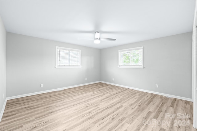 empty room with light wood-style floors, baseboards, and ceiling fan