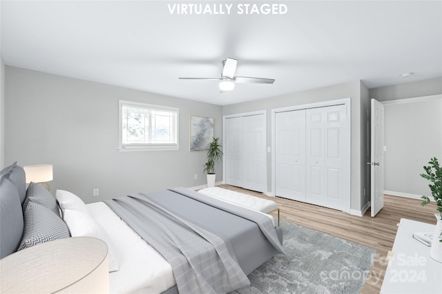 bedroom featuring ceiling fan, multiple closets, and light wood-type flooring