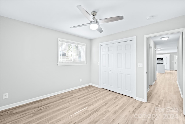 unfurnished bedroom featuring a closet, ceiling fan, and light wood-type flooring