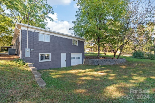rear view of house featuring a lawn, an attached garage, and brick siding
