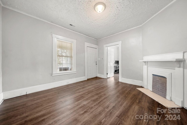 225 Flint St, Charlotte, NC 28216 - unfurnished living room featuring a fireplace, a textured ceiling, ornamental molding, visible vents, and wood finished floors