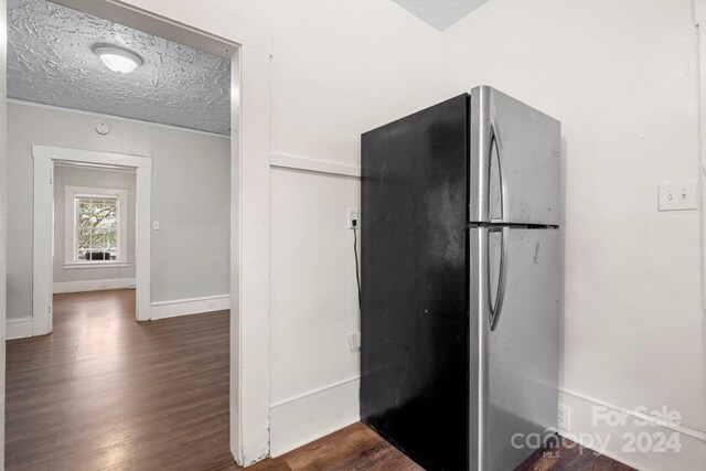 kitchen featuring a textured ceiling, stainless steel refrigerator, and dark hardwood / wood-style flooring