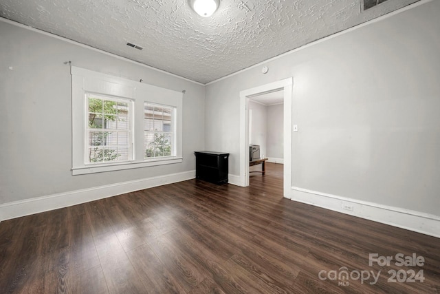 225 Flint St, Charlotte, NC 28216 - unfurnished room with crown molding, dark wood-type flooring, a textured ceiling, visible vents, and baseboards