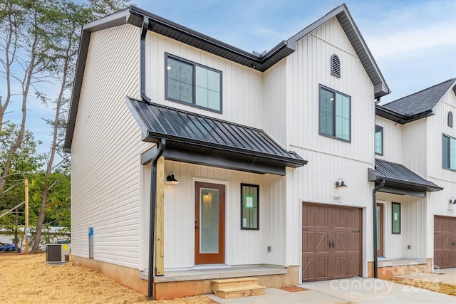 modern farmhouse with central AC unit and a garage