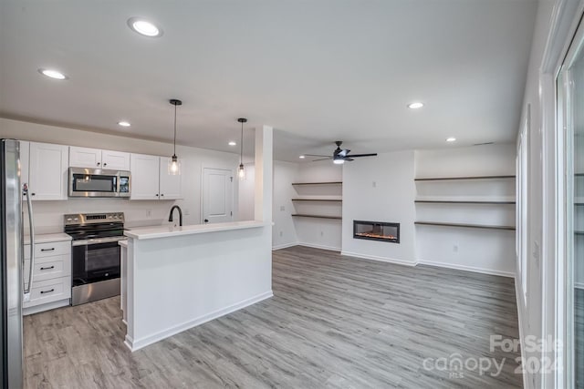 kitchen with light hardwood / wood-style floors, white cabinetry, appliances with stainless steel finishes, decorative light fixtures, and ceiling fan