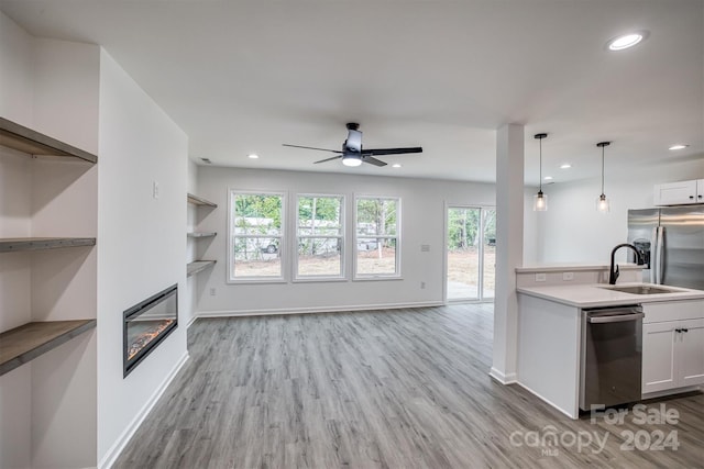 kitchen featuring hanging light fixtures, stainless steel dishwasher, ceiling fan, and white cabinets