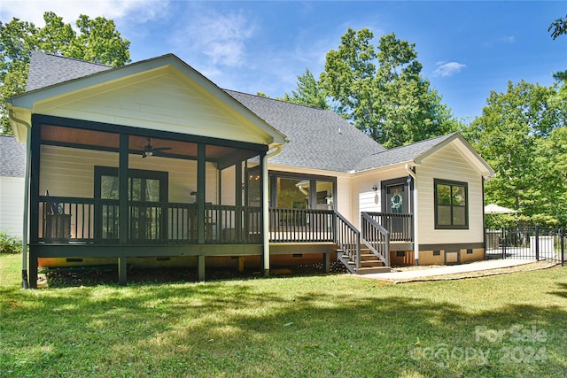 rear view of house featuring a lawn and ceiling fan