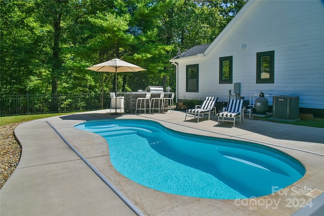 view of swimming pool featuring cooling unit, an outdoor bar, and a patio area