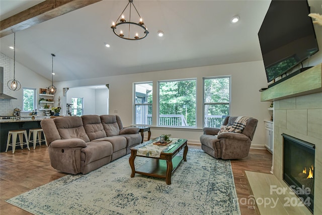 living room featuring hardwood / wood-style floors, a chandelier, and lofted ceiling with beams