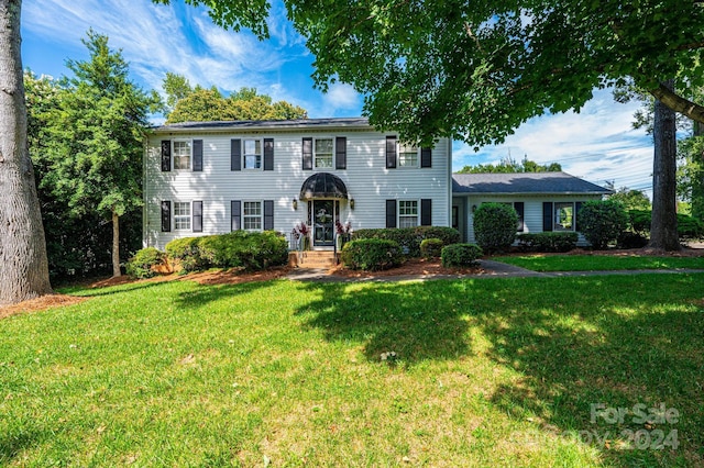 colonial home featuring a front lawn