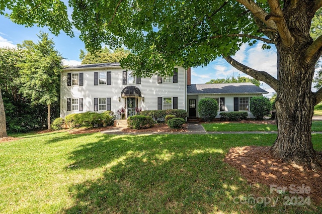 colonial inspired home with a front lawn