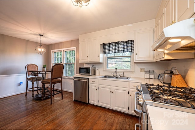 kitchen featuring dark hardwood / wood-style flooring, sink, hanging light fixtures, appliances with stainless steel finishes, and white cabinetry