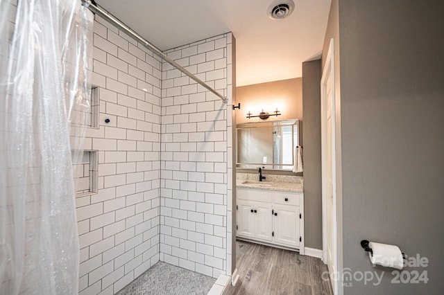 bathroom with walk in shower, vanity, and wood-type flooring