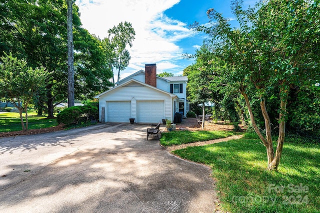 view of side of property featuring a garage and a lawn