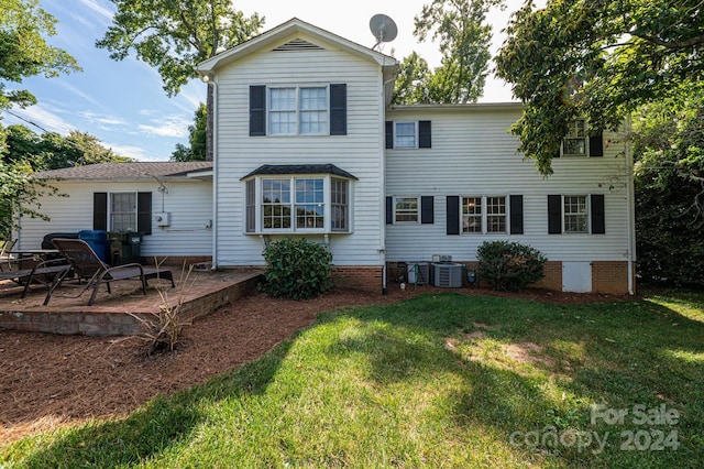 back of property with a yard and a patio