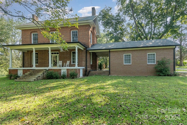 italianate house featuring covered porch, brick siding, and a front yard