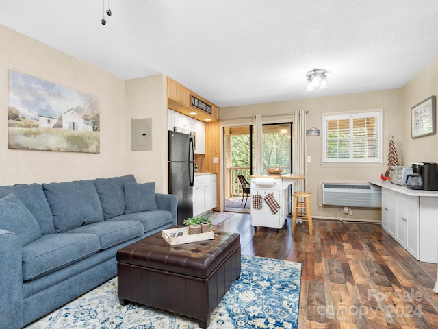 living room with electric panel, dark hardwood / wood-style floors, an AC wall unit, and a textured ceiling