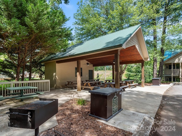 view of patio with ceiling fan and an outdoor fire pit