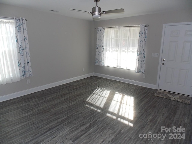 empty room with ceiling fan and dark hardwood / wood-style flooring