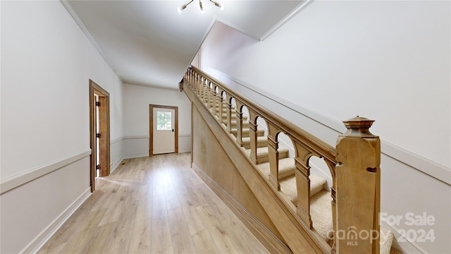 staircase featuring crown molding and hardwood / wood-style flooring