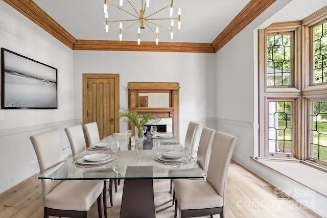 dining space with crown molding, a healthy amount of sunlight, a notable chandelier, and light hardwood / wood-style floors