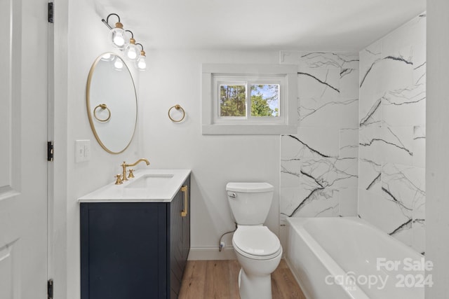 full bathroom featuring tiled shower / bath combo, toilet, hardwood / wood-style flooring, and vanity