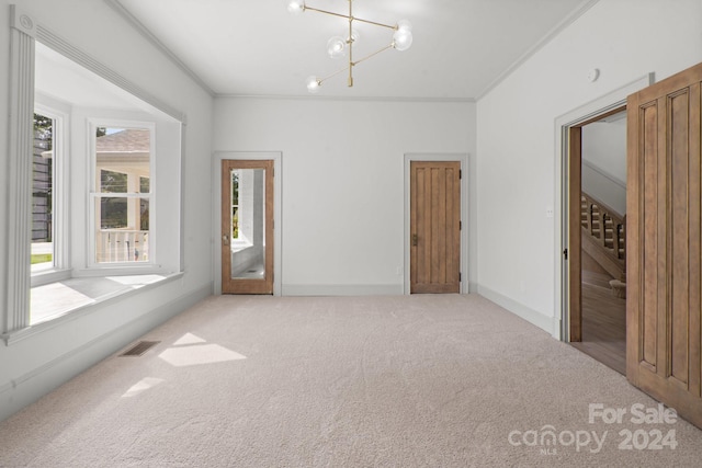 carpeted spare room with a chandelier and crown molding