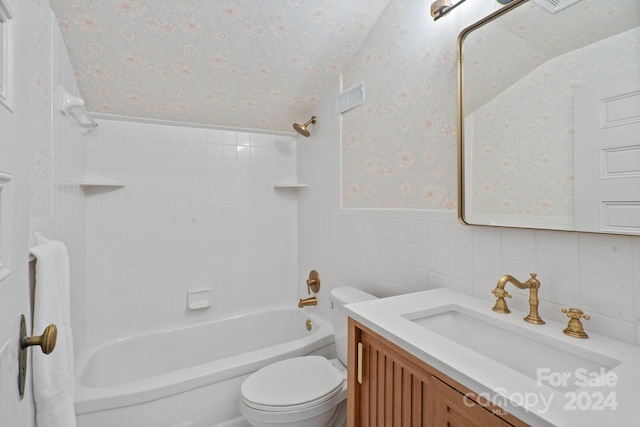 full bathroom featuring tiled shower / bath, toilet, tile walls, decorative backsplash, and vanity