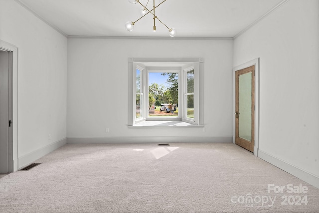 spare room featuring a notable chandelier, light colored carpet, and crown molding