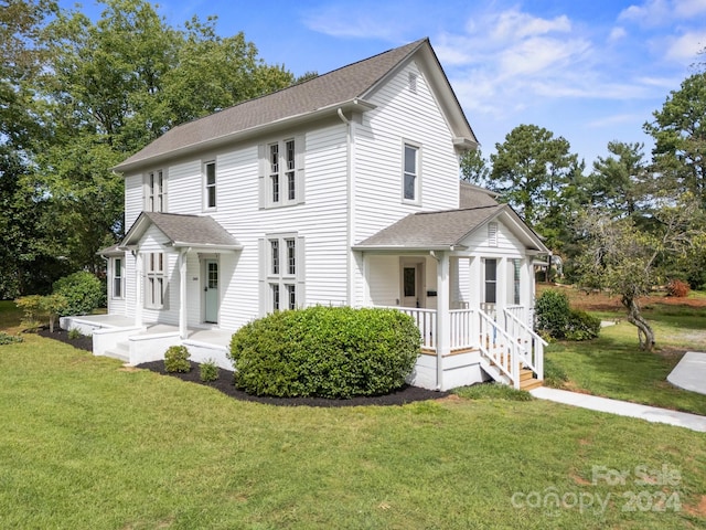 view of front of home with covered porch and a front lawn