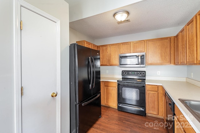 kitchen with dark hardwood / wood-style floors, sink, a textured ceiling, and black appliances