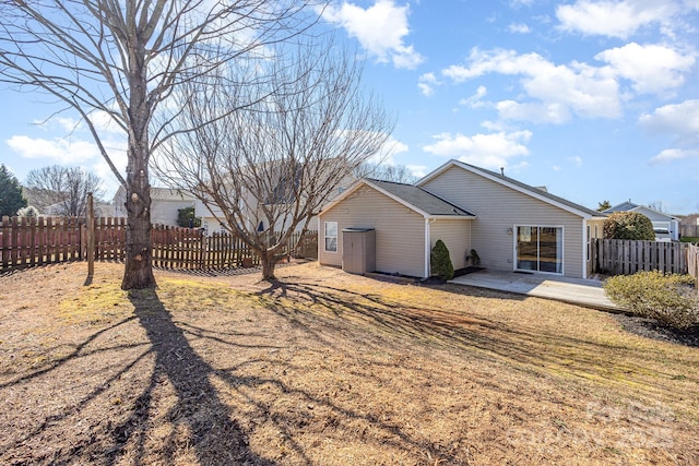 back of house with a yard and a patio